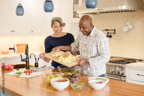 Couple laughing together while cooking photo