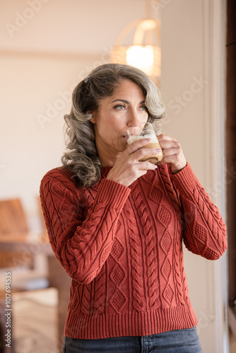 Woman looking out the window drinking coffee photo