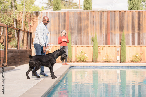 Large dog with owners near a pool photo