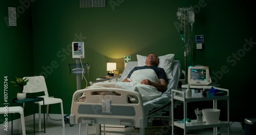 Senior patient lies with closed eyes in a hospital room, his face adorned with an oxygen tube for support.