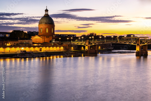 Golden sunset over Garonne river with views on the the pedestrian Saint-Pierre bridge, Place Saint-Pierre and the Grave hospital seen from the riverside  photo