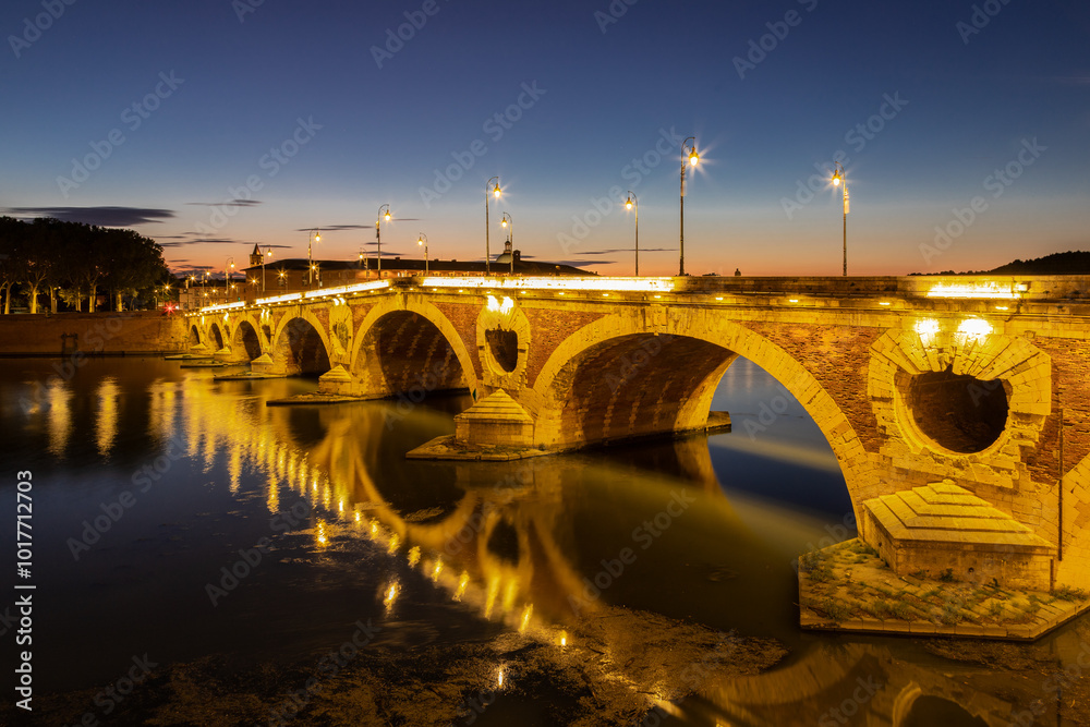 Golden sunset over the Garonne river and Pont Neuf in downtown Toulouse. This arch bridge is considered a masterpiece of the Renaissance. The bridge is not symmetrical. Golden sunset over the Garonne river and Pont Neuf in downtown Toulouse. This arch bridge is considered a masterpiece of the Renaissance. The bridge is not symmetrical.
