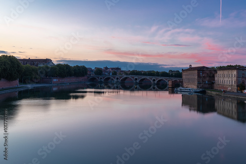 Golden sunset over Garonne river with views on the the pedestrian Saint-Pierre bridge, Place Saint-Pierre and the Grave hospital seen from the riverside 