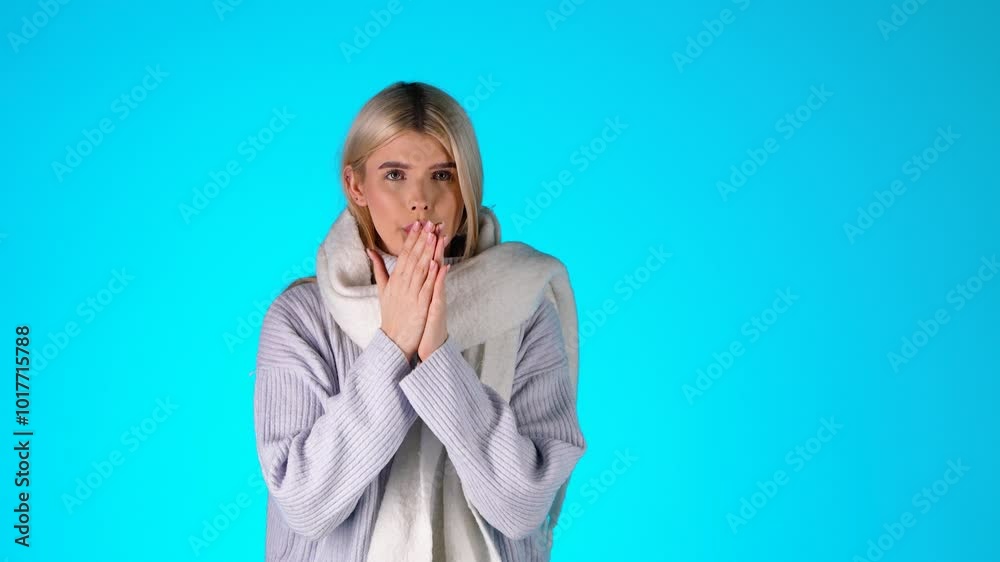Portrait Of Young Blonde Woman Feeling Cold, Wearing Scarf Grey Sweater and Earmuffs, Studio Shot With Pink Background Portrait Of Young Blonde Woman Feeling Cold, Wearing Scarf Grey Sweater and Earmuffs, Studio Shot With Pink Background