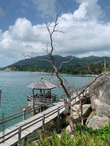 Wooden pier with gazebo overlooking tropical sea and mountains