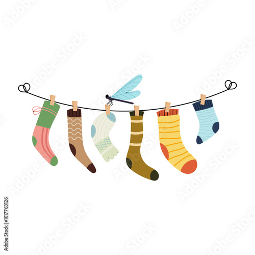 Set of children socks hanging on the rope clothesline with clothespins. Dragonfly insect. Set of different socks. Washing clothes.