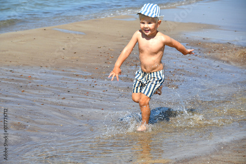 Cute little boy having fun on the sandy Baltc beach in summer. photo