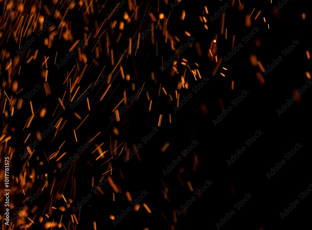 The image is a close up of a black background with a lot of orange sparks The image is a close up of a black background with a lot of orange sparks
