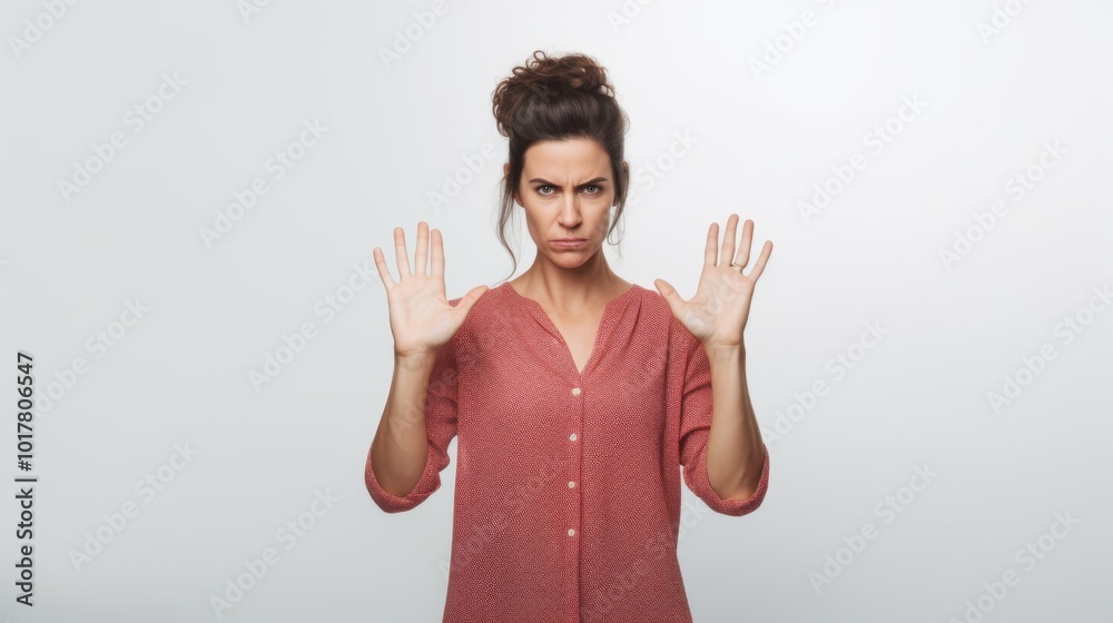 A woman in a red shirt emphatically raises her hands in a halting gesture, capturing a moment of strong emotion and resolve. A woman in a red shirt emphatically raises her hands in a halting gesture, capturing a moment of strong emotion and resolve.