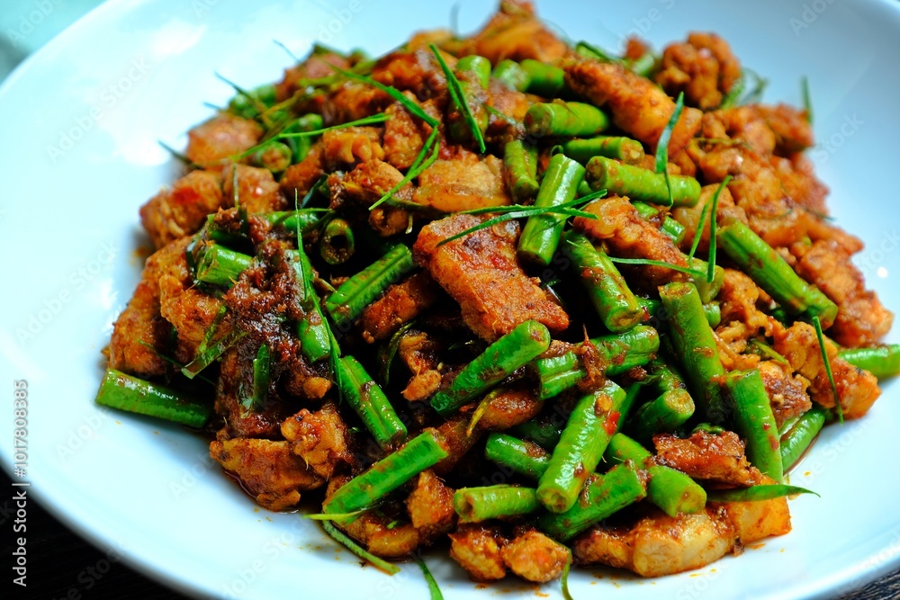 Stir fried crispy pork belly and yard long bean with ginger red curry paste, Authentic Thai food.