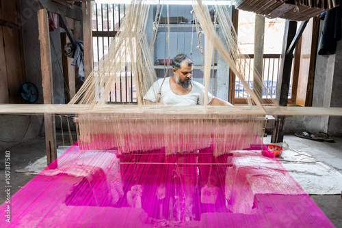 Billede på lærred Indian man sitting at handloom weaving with purple thread