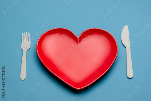 Heart on a blue with a plate. Food love rtic concept. Heart shaped plate on a blue. Red and blue heart shaped plate on a white lifestyle. photo