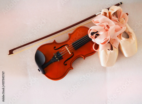 Pair of Ballet shoe put beside wooden violin and bow,