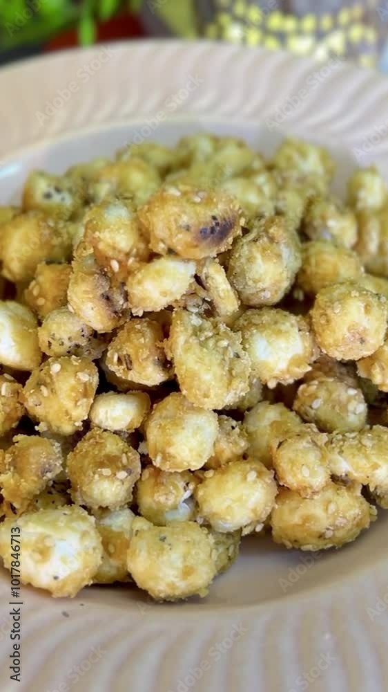 sweet Makhana, also called as Lotus Seeds made with jaggery in a ceramic plate. sweet Makhana, also called as Lotus Seeds made with jaggery in a ceramic plate.