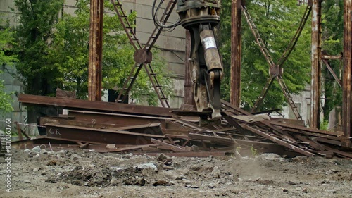 Demolition site with heavy machinery breaking metal structures and scattering debris. Industrial environment with dust and rubbl. photo