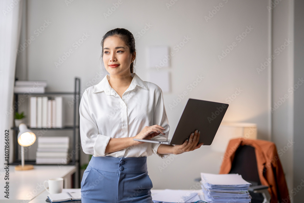 Businesswoman working on laptop and thinking about project in modern office Businesswoman working on laptop and thinking about project in modern office