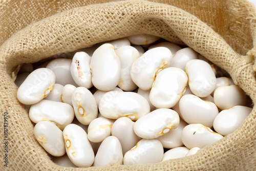 Bag of white beans and crocheted hat. brown texture concept. bag of white beans lying in field under bright light. a young girl lying in a bag of white beans in a dark room with a lifestyle light on. photo