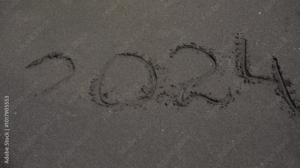 2024, written on black magnetic sand. Sea wave washes away inscription 2024, passing year, on sand and it disappeared without trace. 
