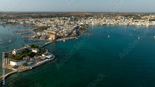 Aerial view of Cesarea Tower located in Porto Cesareo in Salento, Puglia, Italy. The medieval tower overlooks Mediterranean Sea at sunset.