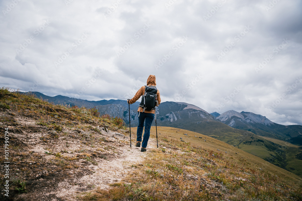 Woman backpacker hiking on high altitude mountains top Woman backpacker hiking on high altitude mountains top