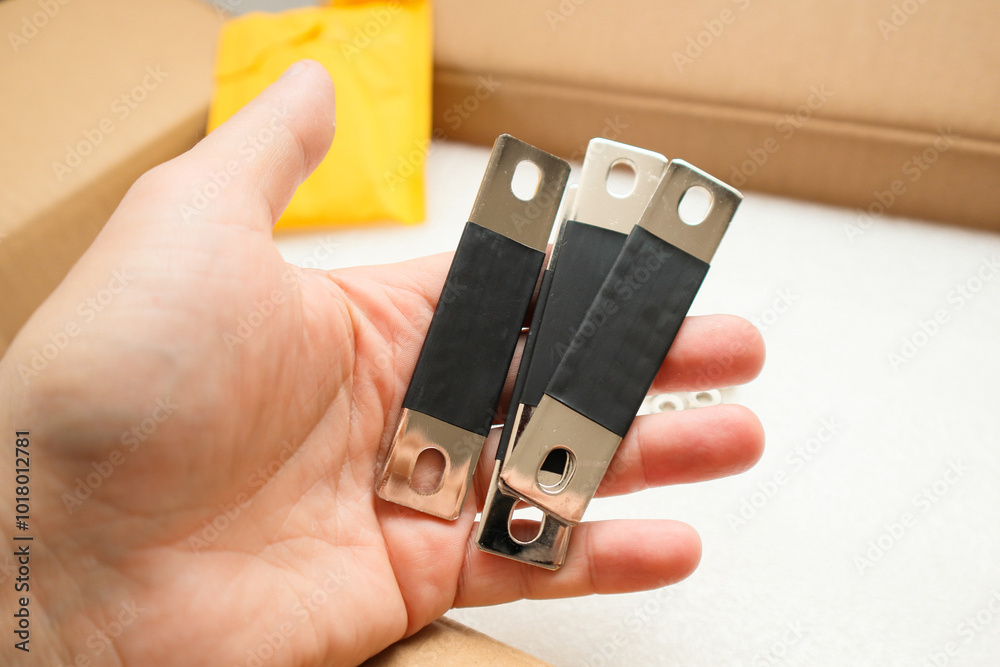 Mans hand with copper bus bar for lifepo4 prismatic cell battery Mans hand with copper bus bar for lifepo4 prismatic cell battery