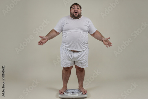 Big fat man stands and weighs himself on scales. photo