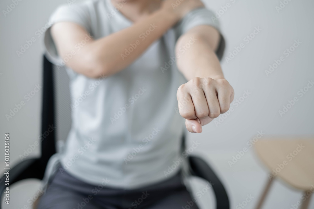 Asian female accountant is tired from working in a chair have Shoulder pain, stretching to relax and relax while working hard at the office Asian female accountant is tired from working in a chair have Shoulder pain, stretching to relax and relax while working hard at the office