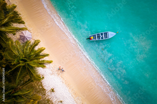 Drone view of two little kids playing in the sand and building a sand castle on a beautiful tropical beach near Grand Baie, Mauritius