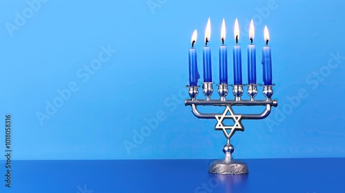 silver hanukkah menorah with blue candles lit against background copy space festive celebration