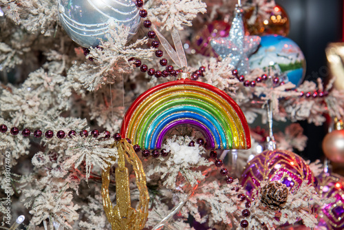 A Christmas ornament in the Shape of a rainbow on a festive Christmas tree indicating a gay or lesbian LGBTQ+ Christmas