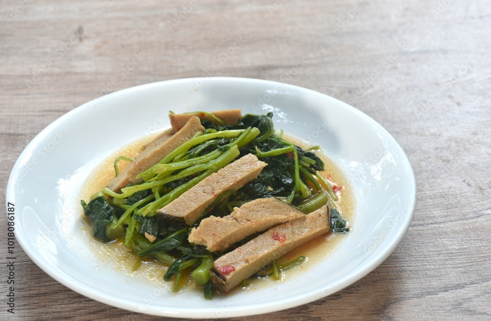 fried Chinese kale with slice gluten vegetarian food on plate fried Chinese kale with slice gluten vegetarian food on plate