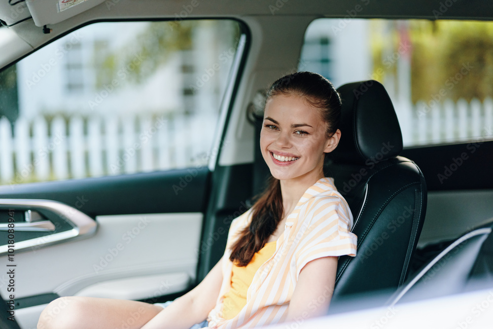 cheerful young woman smiling in car, sitting in driver s seat, summer outfit with soft colors, bright background with greenery and white fence, joyful expression, lifestyle concept cheerful young woman smiling in car, sitting in driver s seat, summer outfit with soft colors, bright background with greenery and white fence, joyful expression, lifestyle concept