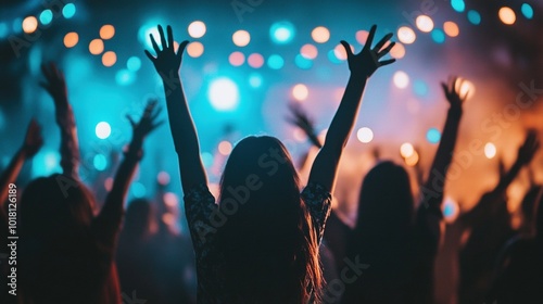 Silhouettes of people rising their hands and having fun at the music open air festival. Nightlife. People dancing at rock concert and going wild. There are orange stage lights. On stage are musicians.