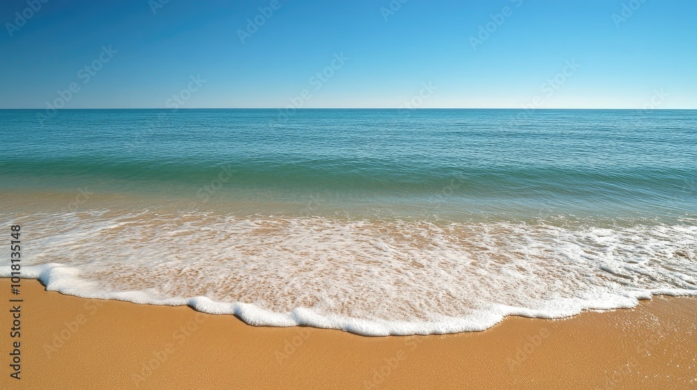 Wide view of gentle ocean waves rolling onto a sandy beach, with a clear sky and distant horizon Wide view of gentle ocean waves rolling onto a sandy beach, with a clear sky and distant horizon