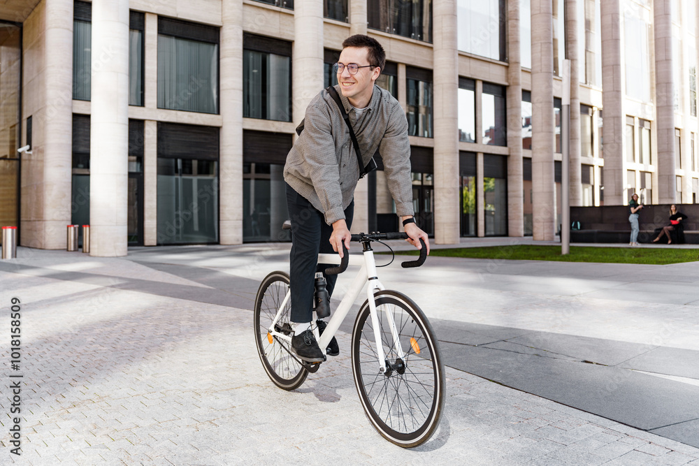 A Young Man Rides a Stylish White Bicycle Through a Modern Urban Landscape on a Sunny Day A Young Man Rides a Stylish White Bicycle Through a Modern Urban Landscape on a Sunny Day