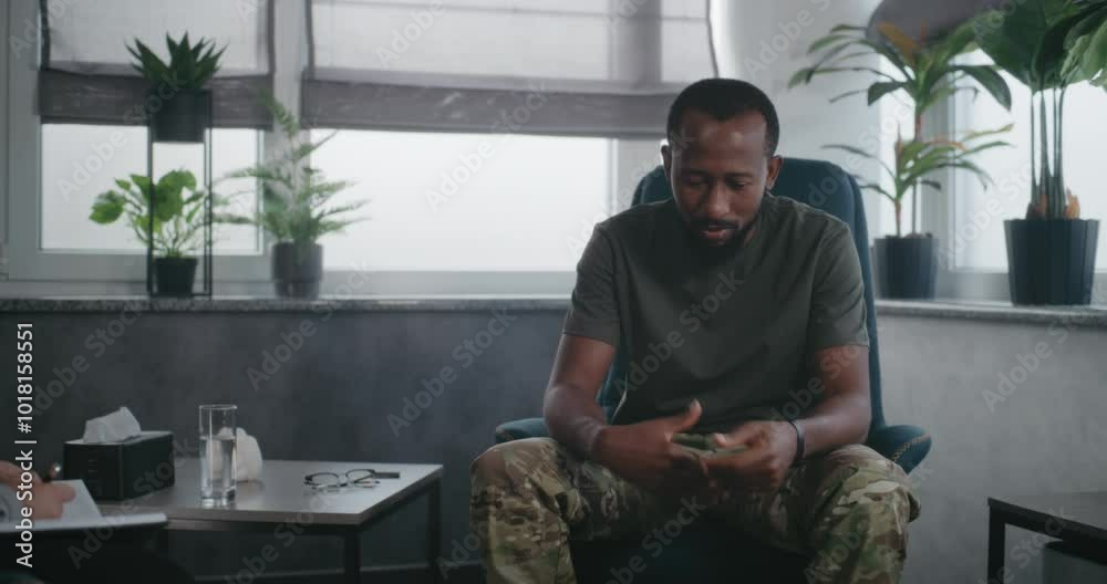 Depressed African American soldier with PTSD talks to psychologist, shares traumatic experience on therapy session. Female therapist listens military man, takes notes. Post traumatic stress disorder. Depressed African American soldier with PTSD talks to psychologist, shares traumatic experience on therapy session. Female therapist listens military man, takes notes. Post traumatic stress disorder.