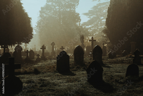 A spooky Victorian graveyard. With graves silhouetted by fog on a mysterious creepy winters night.