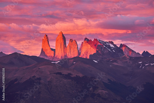 This stunning sunrise view at Lake Azul (Lago Azul) in Torres del Paine National Park, Chile, captures the iconic peaks of the Torres bathed in vibrant pink hues.