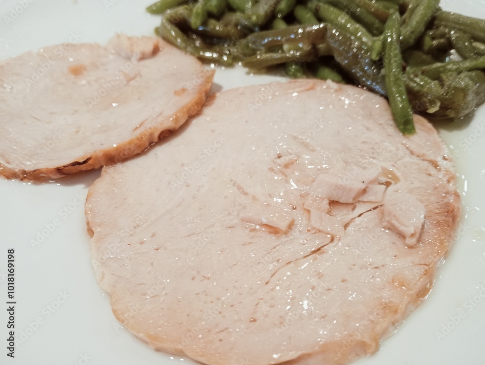 Plate with sliced turkey meat and green beans