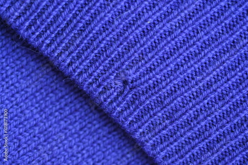 Close-up of a darned hole in a purple woollen fabric, darned hole in a sweater  photo