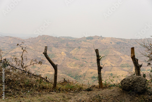 Barbed wire fence overlooking arid hills in El Salvador photo