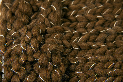 Fragment of very thick wool texture in dark brown color with white interlaced thread