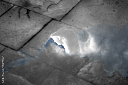Wallpaper Mural Reflection of white and lush clouds on blue sky in puddle of water on defocused cobblestone floor Torontodigital.ca