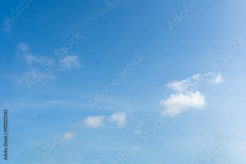 Fluffy white clouds drift across a clear blue sky, painting a breathtaking canvas of nature's beauty