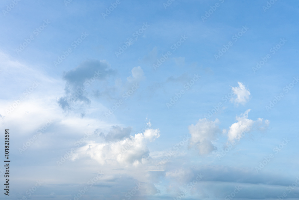Fluffy white clouds drift across a clear blue sky, painting a beautiful summer day Fluffy white clouds drift across a clear blue sky, painting a beautiful summer day