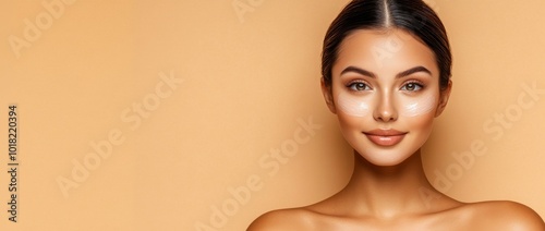 The essence of facial care and beauty treatments is illustrated by this beautiful young Asian woman with fresh skin, against a neutral beige background