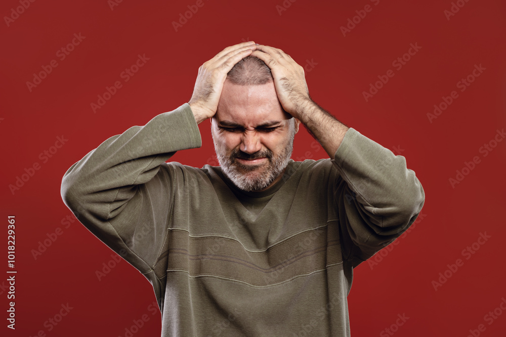 man feeling pain with hands on head