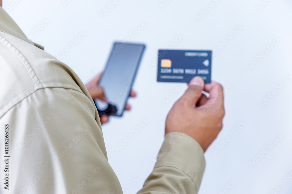 A person holding credit cards and a phone, ready for a transaction or payment. A person holding credit cards and a phone, ready for a transaction or payment.
