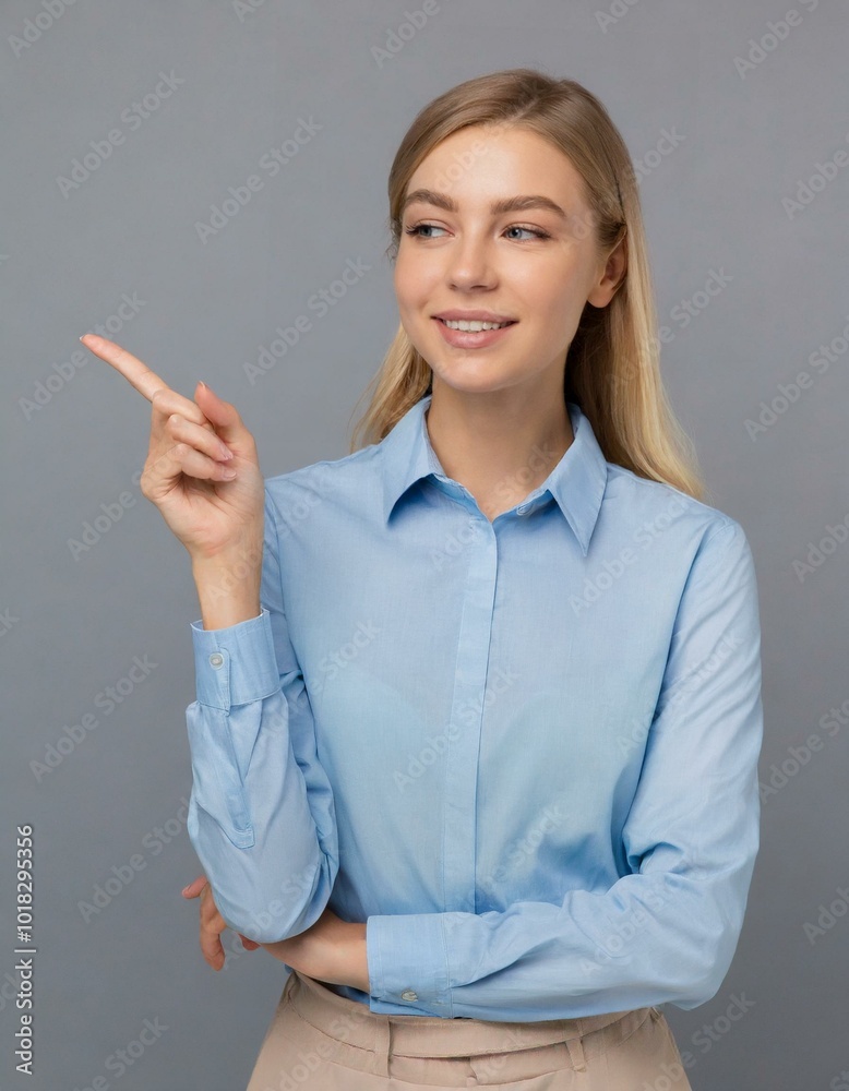 Happy young smiling professional business woman wearing blue shirt looking at camera pointing finger away at copy space showing aside Happy young smiling professional business woman wearing blue shirt looking at camera pointing finger away at copy space showing aside