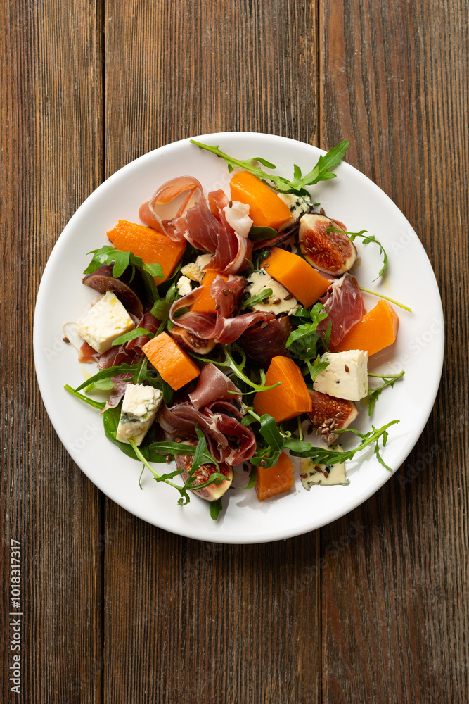 Jamon blue cheese and figs butternut pumpkin salad rocket on white plate Jamon blue cheese and figs butternut pumpkin salad rocket on white plate